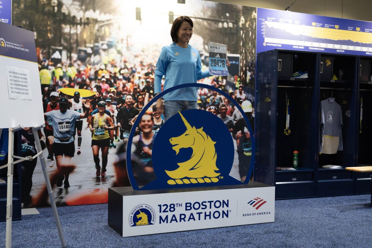 Jacqueline Chow poses with her bib number in front of a Boston Marathon prop at the marathon expo.