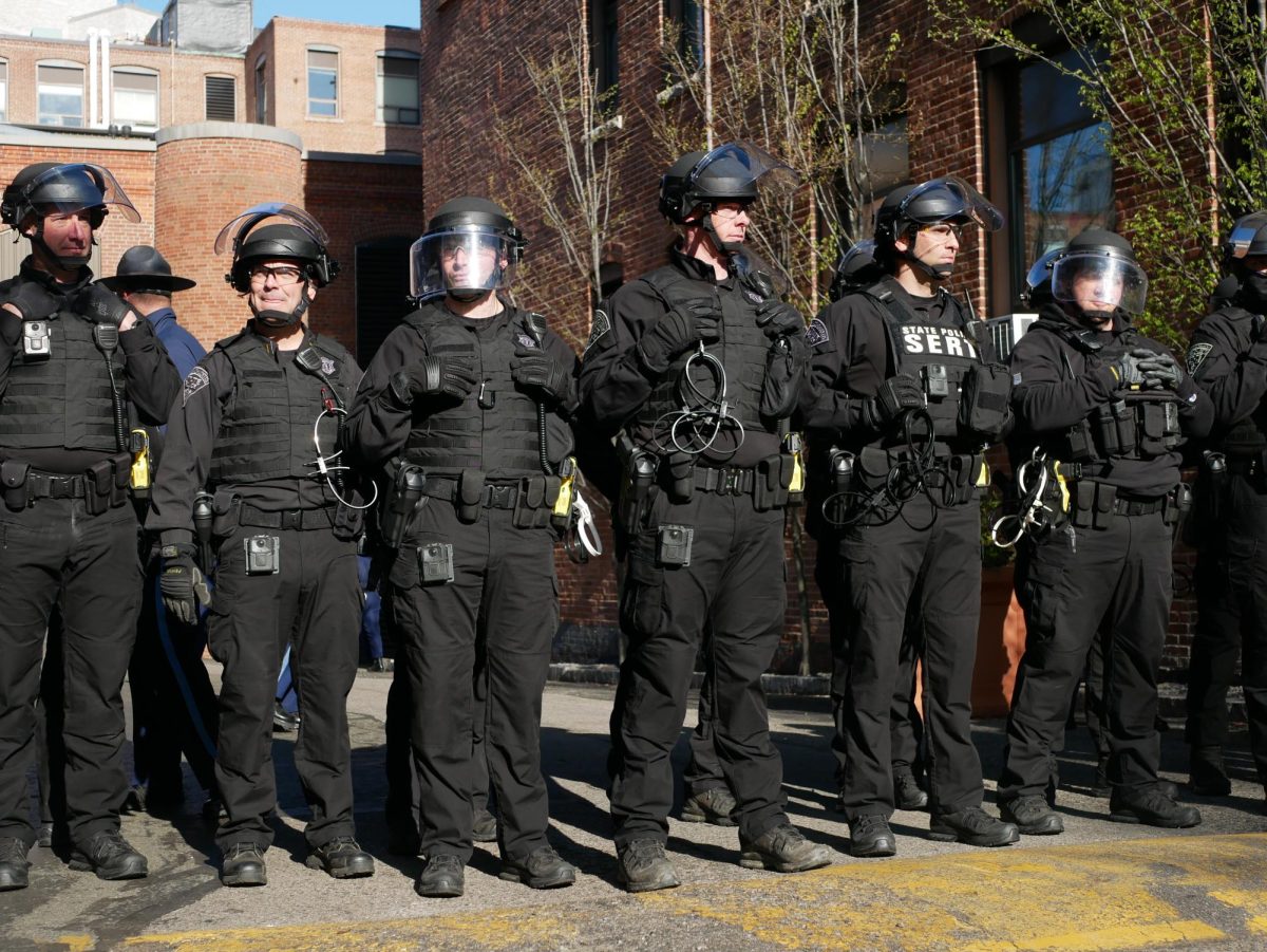 Police officers in riot gear stand in a line outside Shillman Hall. Arrests began at around 7:00 a.m. Saturday morning.