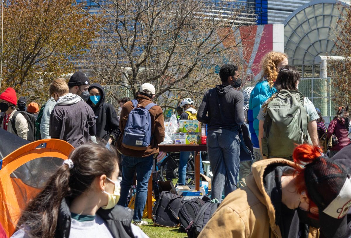 Protesters gather around a resource table at the center of the encampment. The table was used to distribute food to demonstrators.