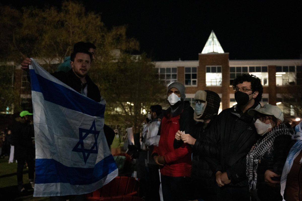 A+counter-protester+holds+up+an+Israeli+flag+in+front+of+pro-Palestine+protesters.+The+statement%2C+kill+the+Jews%2C+was+used+by+Northeastern+as+a+part+of+the+reason+for+clearing+out+the+%E2%80%9CGaza+solidarity+encampment%E2%80%9D+in+Centennial+Common%2C+which+resulted+in+the+detainment+of+over+100+individuals.