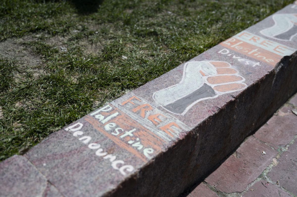 A chalk drawing on the edge of Centennial reads FREE Palestine Denounce.