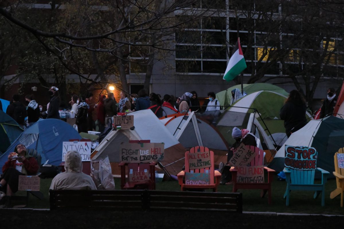 Protesters gather around the encampment as night falls. Power to Centennial Common was shut off around 6:50 p.m.