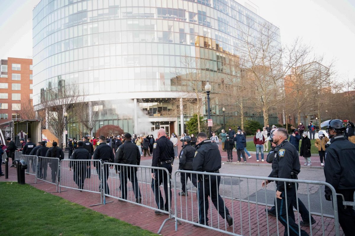 BPD officers walk alongside the barricade surrounding Centennial. Protesters remained linked in a circle around the encampment.