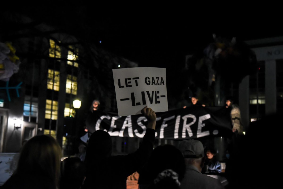 A Havdalah attendee holds up a sign that reads, LET GAZA LIVE.
