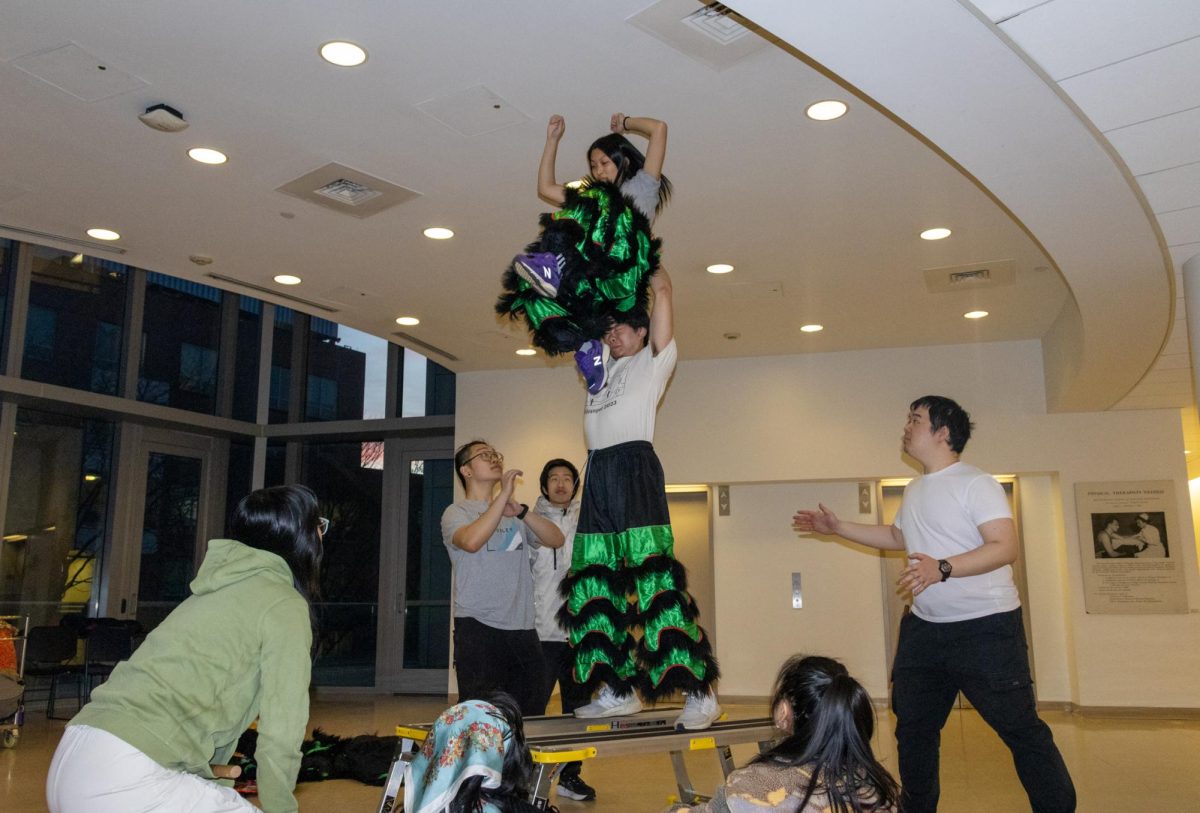 Dragon & Lion Dance Troupe members practice new acrobatic dance moves. Lion dancers traditionally performed flashy acrobatic tricks called “stacks.”