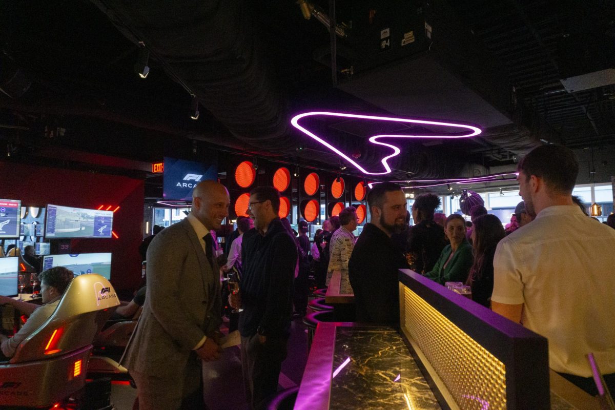 Guests chat and socialize with each other in the main area. The arcade’s decor was inspired by various elements of F1, such as the ceiling lights, which resembled racing circuits, and the red lights, modeled after F1 track lights.