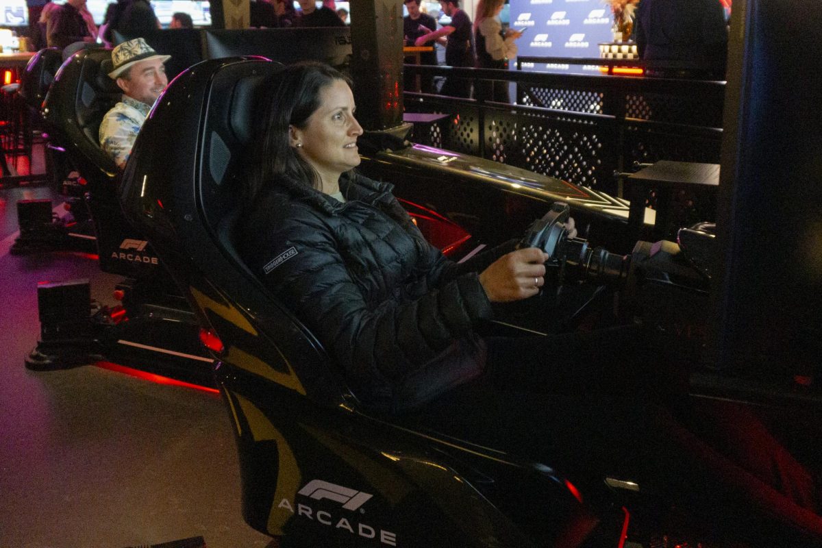 A woman smiles as she successfully overtakes another car in the simulator. The racing simulator seats immersed guests with built-in speakers and physical feedback.
