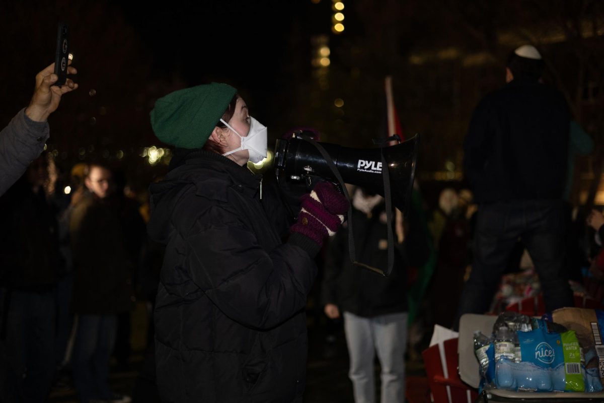 A pro-Palestine demonstrator uses a megaphone to inform the protesters to not engage with the pro-Israel protesters. 
