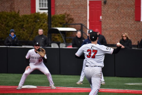 Senior Jake Gigliotti prepares to make a pass to graduate student Tyler MacGregor. MacGregor secured both a run and an RBI single in the Saturday afternoon matchup against UNCW.