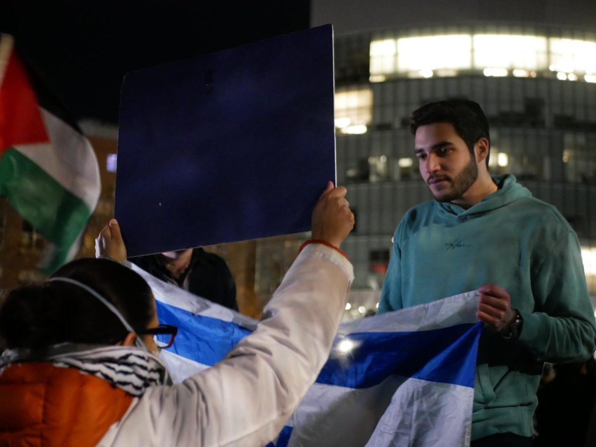 A pro-Israel protester holds and Israeli flag during a confrontation with pro-Palestinian encampment protesters. Huskies for a Free Palestine said in a statement that the pro-Israel counter-protesters tried to instigate people to engage in confrontation and spread further hate speech.