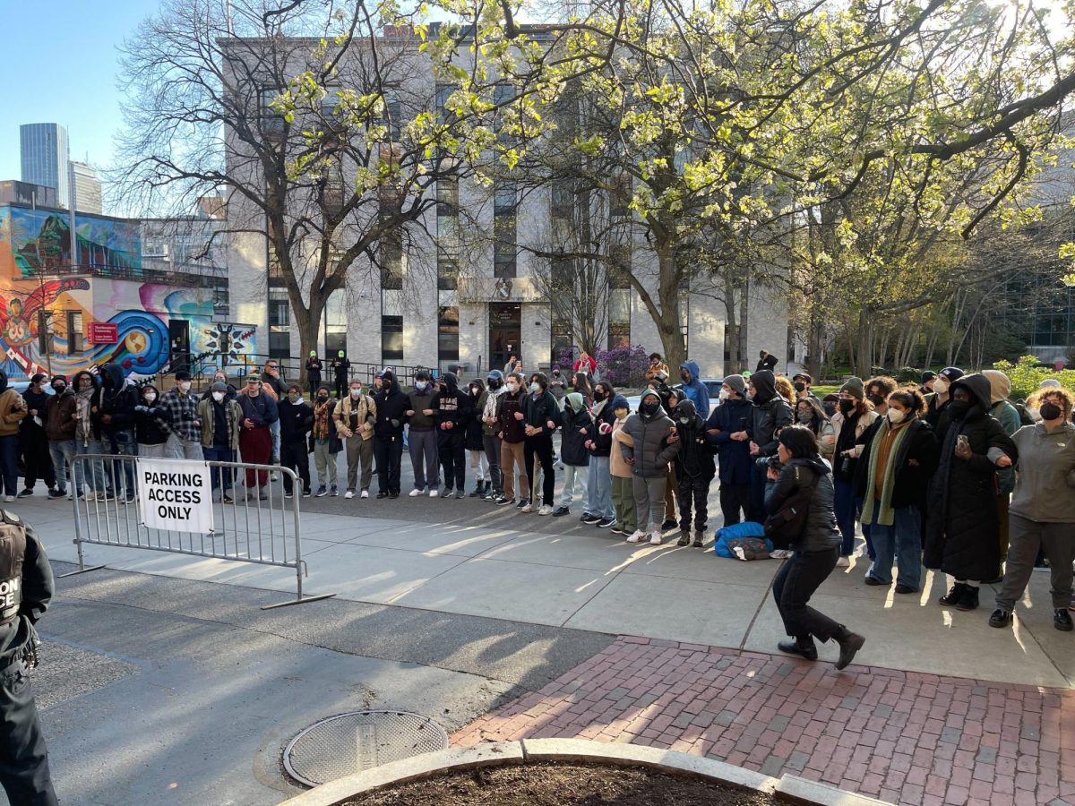Protesters form a human chain to block vans containing arrested students from leaving campus. Sheriff vans moved the arrested protesters to the Nashua Street Jail.