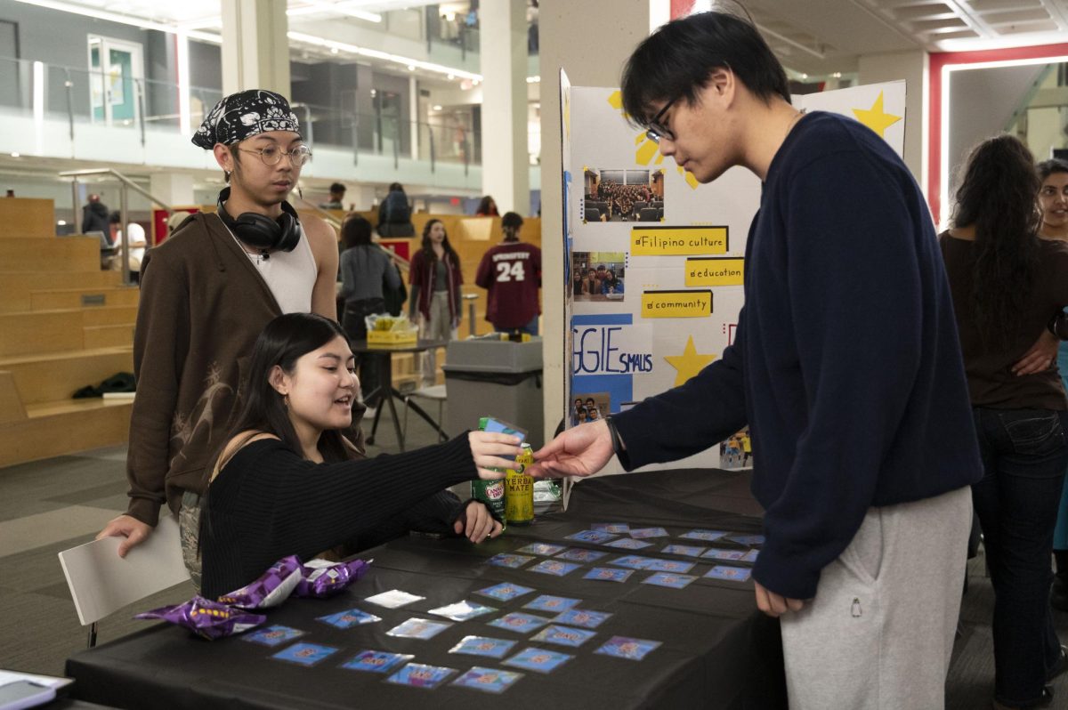 A member of NU Barkada, Northeastern’s Filipino student organization, hands a student a card for the table’s matching game. The indoor quad fair gave cultural student organizations a chance to meet new people. “The culture area in specific has been a huge hit because we were able to really highlight cultural clubs that don’t necessarily get as much press as other ones,” Kawakami said.