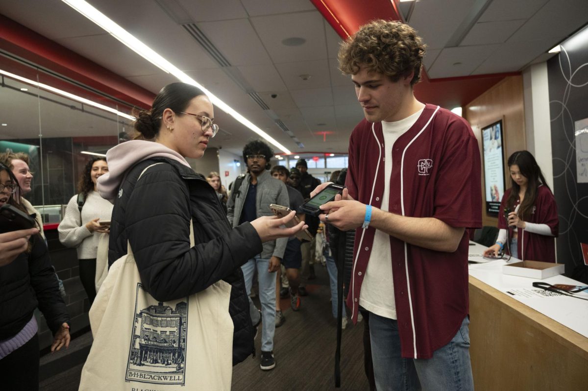 Nolan Mungovan, a third-year computer science major and CUP’s vice president of finance and operations, scans a student’s digital carnival ticket. Students pre-ordered free tickets online for entry.