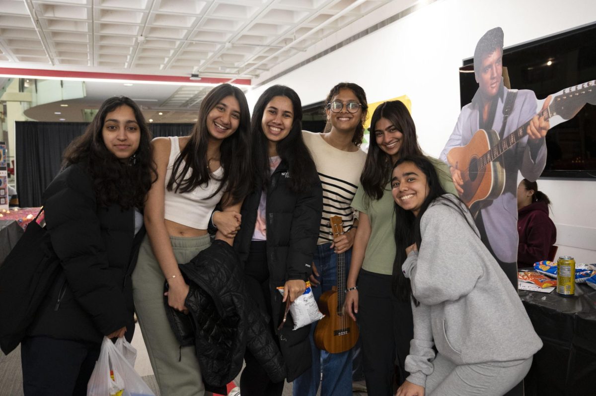 A group of students pose for a photo in the Curry indoor quad. Many students came to the carnival with friends.