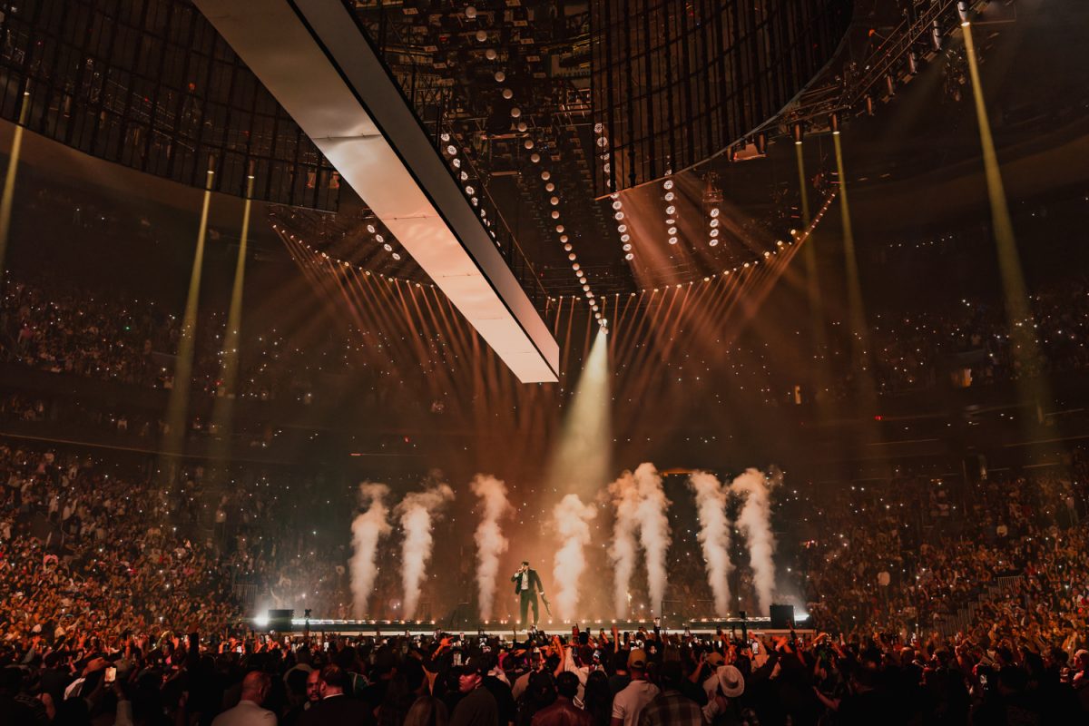 Plumes of orange smoke rise up as Bad Bunny performs on stage.