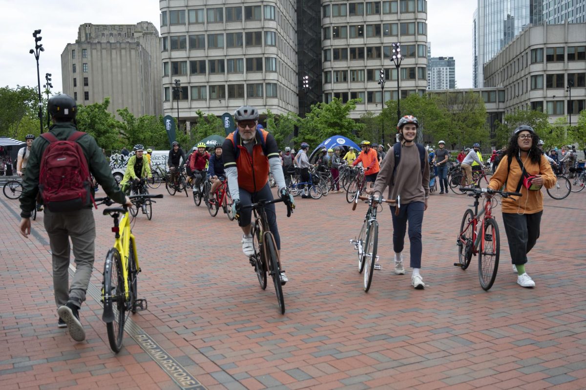 Bikers walk and bike toward the check-in table at the Bike to Work Day Festival. Over 50 groups of about 40 bikers each biked from different municipalities in and around Boston to the festival.