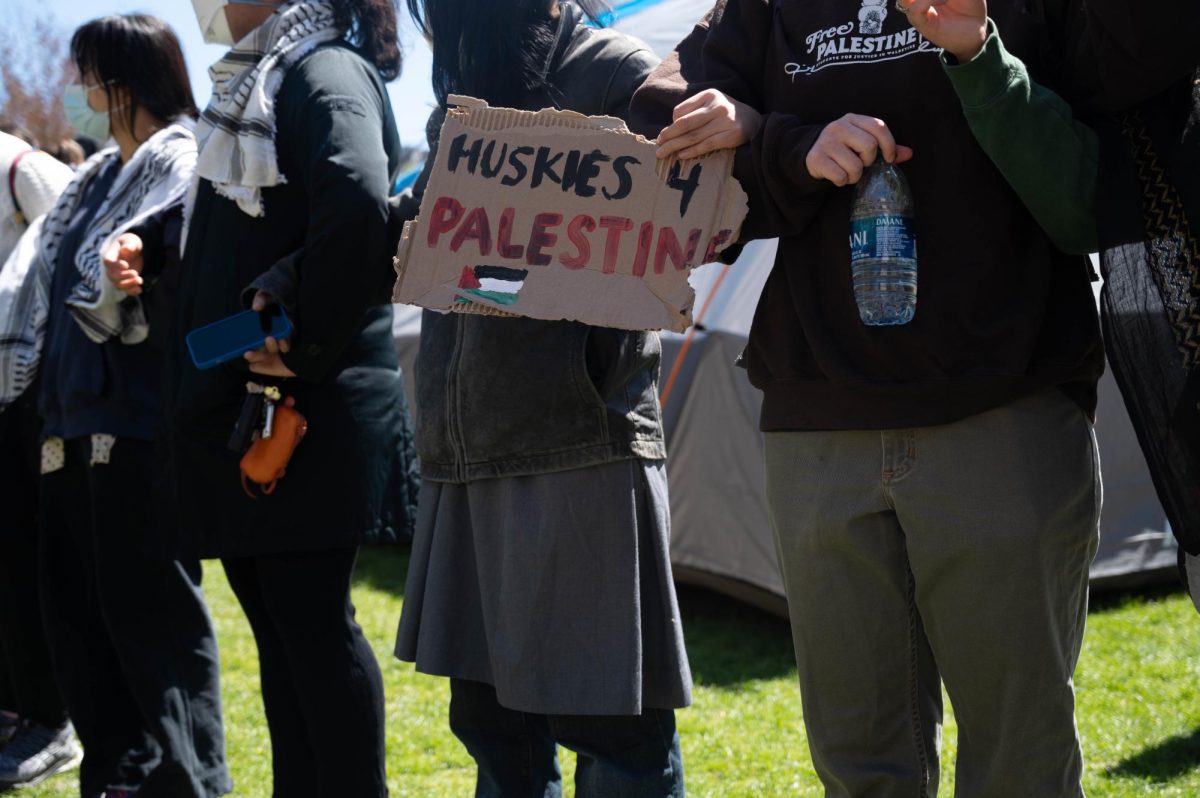 A pro-Palestine protester holds a sign that reads, “Huskies 4 Palestine.” Protesters held a variety of handmade signs throughout the encampment and protests.