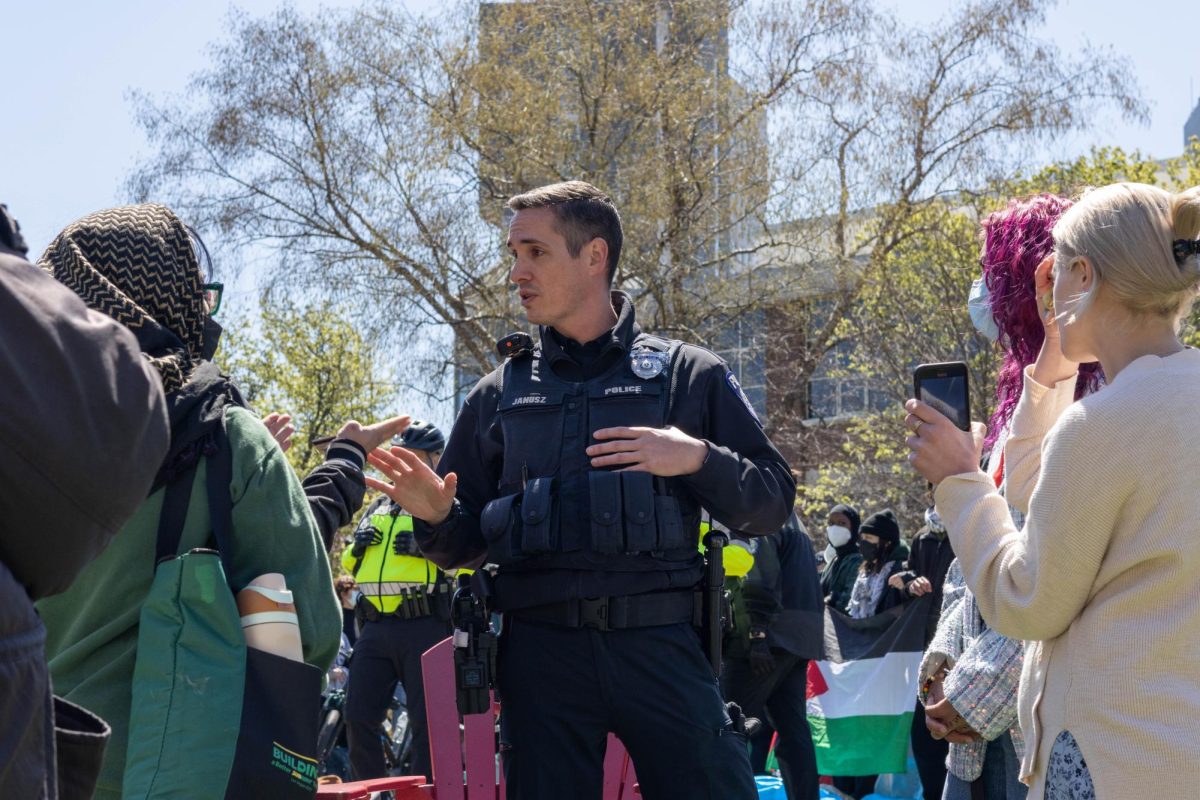 Northeastern University Police Department, or NUPD, officer Ryan Janusz informs a group of people unaffiliated with Northeastern that they must show their Husky Cards to join the protest. Despite not showing IDs, the protesters eventually joined the encampment.