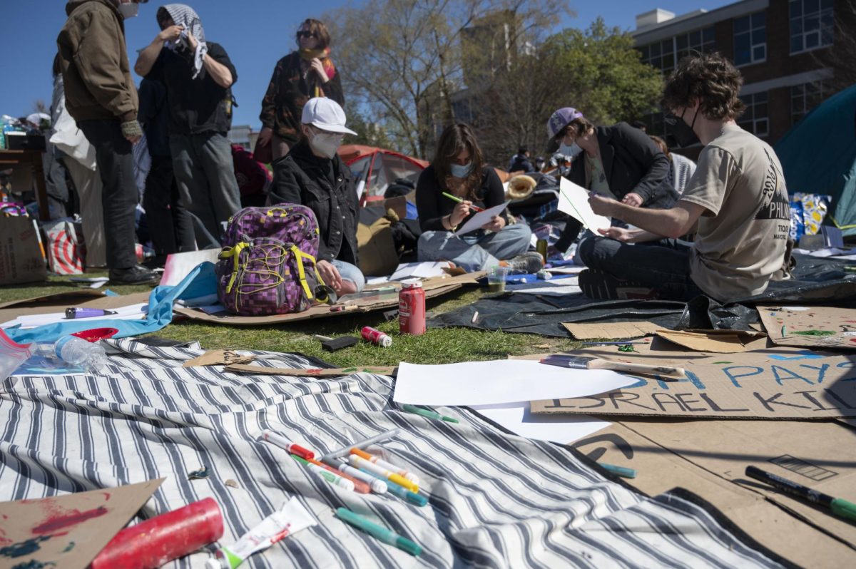 Paints, markers and cardboard sit scattered on a sheet on Centennial. Students spent the afternoon making zines, protest signs and art.