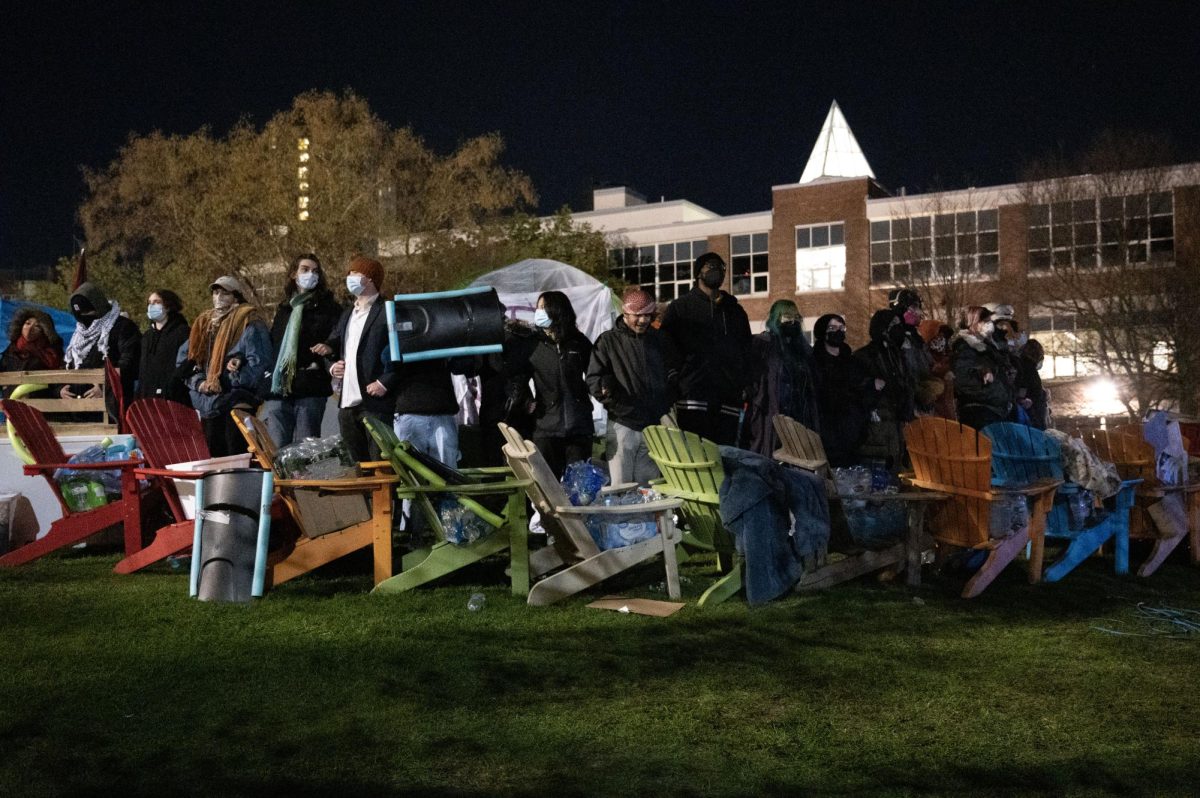 Encampment participants stand in a circle with linked arms April 27. The protesters began preparing for a police raid around 4 a.m. after photos of a moving truck parked nearby were sent in an HFP Telegram channel.