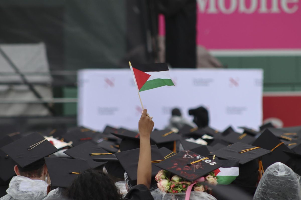 A graduate holds up a Palestinian flag during the undergraduate commencement ceremony May 5. Many students took the opportunity to voice their solidarity with Palestine during the commencement.