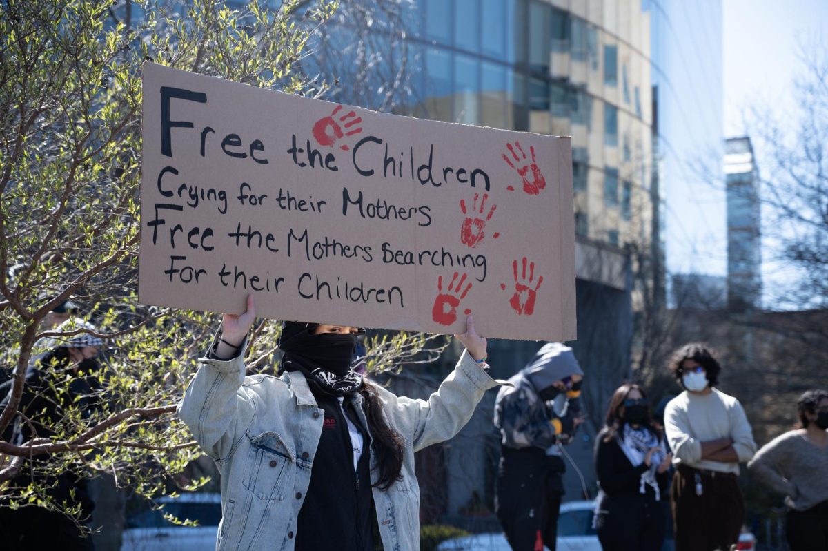 A protester holds a sign that reads, “Free the Children Crying for their Mothers, Free the Mothers Searching For their Children.” Around 3:25 p.m. over two dozen protesters marched around Centennial twice.