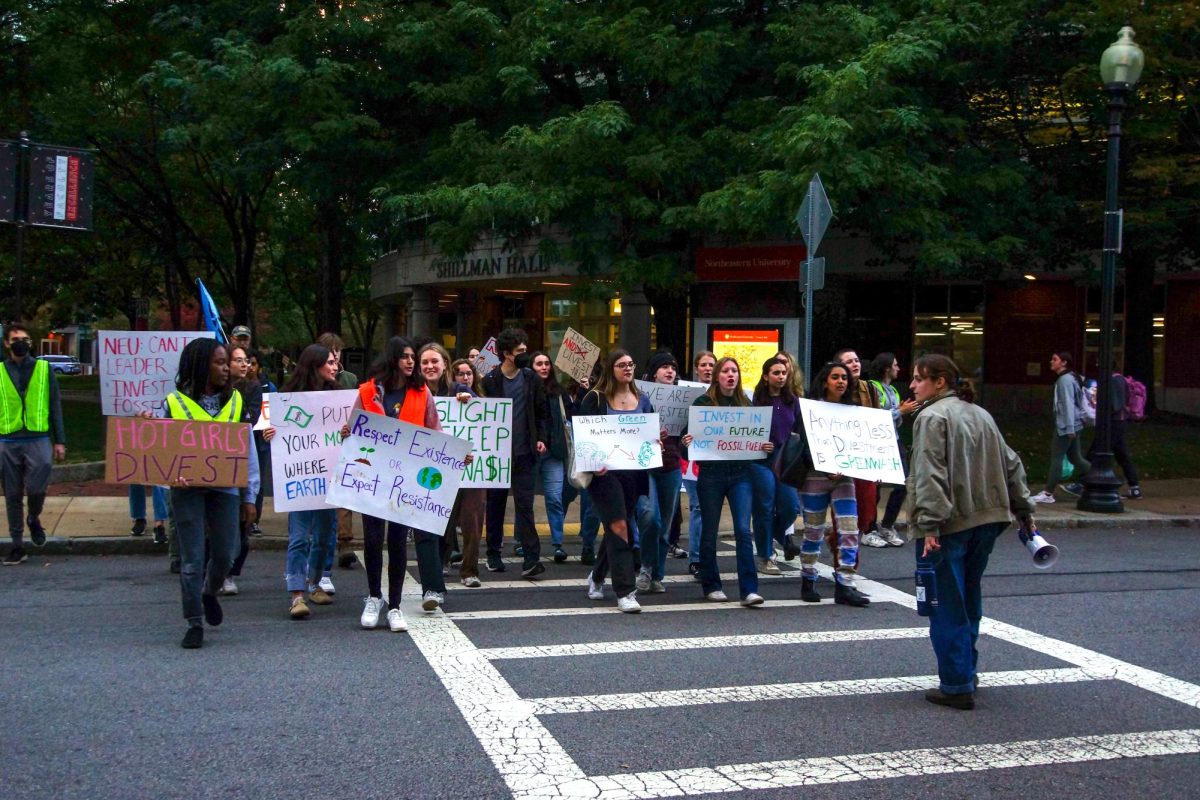 Activists hold signs while crossing Forsyth Street during a DivestNU protest against Northeastern's investments in fossil fuels Oct. 15, 2023. Many Northeastern students joined DivestNU and Sunrise Northeastern to become more involved in climate activism. File photo by Erin Fine.