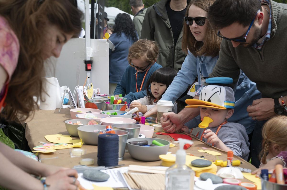 Parents help their children decorate paper ducks using supplies from the Minni tent. Along with arts and crafts, children participated in free face painting, origami and temporary tattoos. 