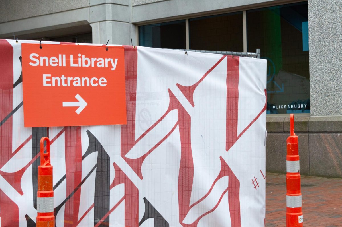 A sign that reads, Snell Library Entrance points students to the side entrance of Snell Library during the temporary closing of the front entrance. It was announced to Boston campus students through an email May 17 that Snells front entrance will reopen May 20, after which the side entrance will close until library renovations are complete in the fall. File photo by Quillan Anderson. 