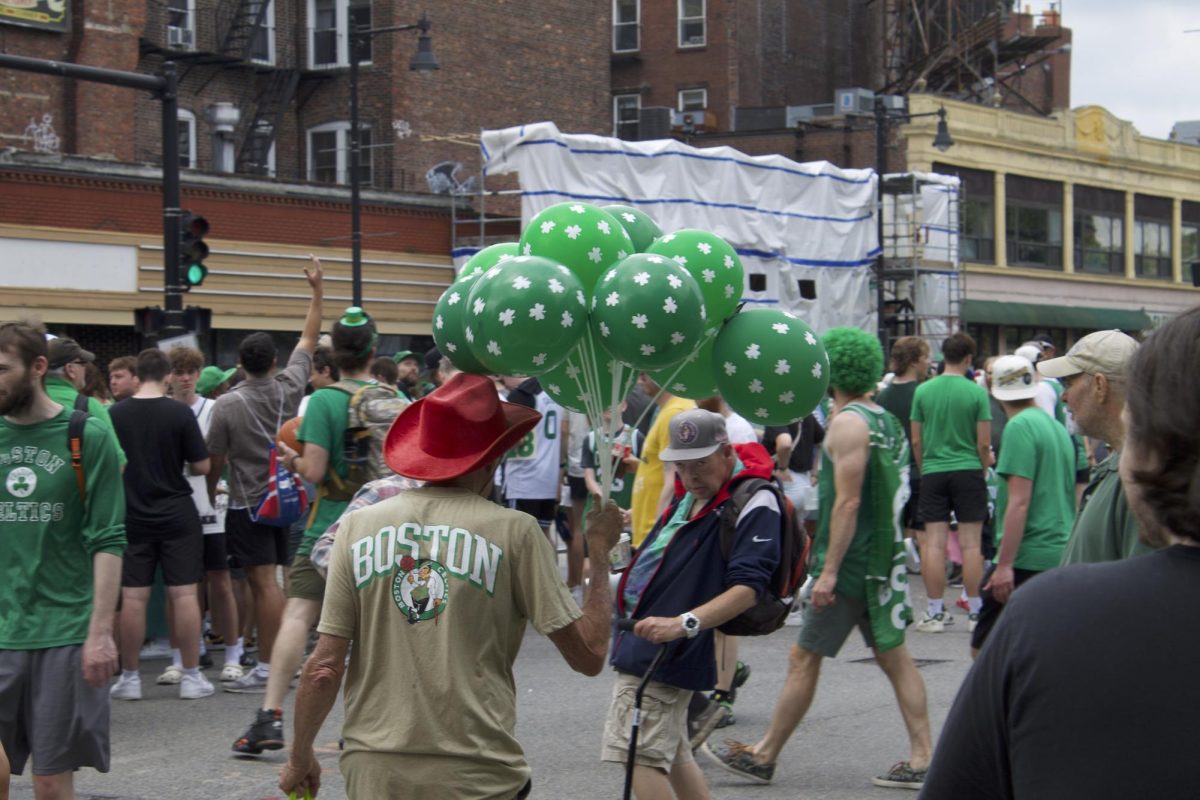 A seasoned fan carries a bouquet of shamrock balloons. Vendors sold hats, shirts, flags, horns, drums and more.
