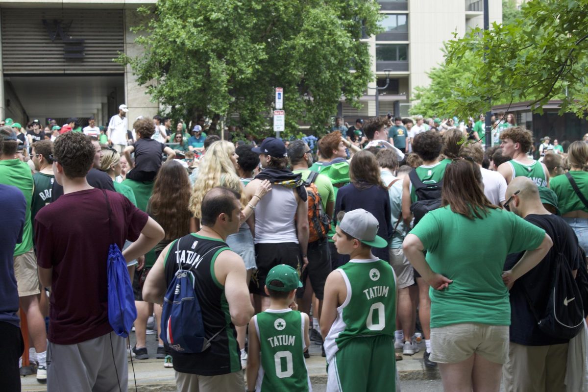 A father and his sons wearing Jayson Tatum jerseys await the parade procession. Many full families, from grandparents to grandchildren, shared in the celebration.