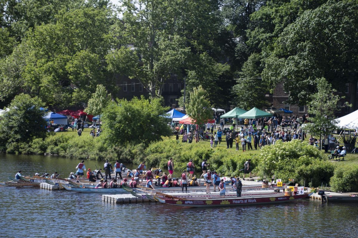 Competitors exit their dragon boats as other competitors prepare to board. The festival welcomed hundreds of participants and spectators.