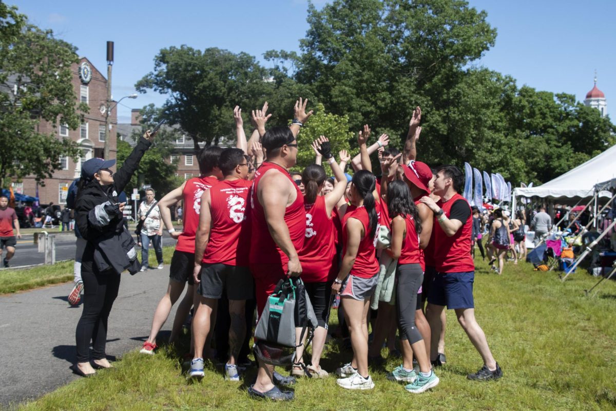 Members of a dragon boat team raise their arms up during a team chant prior to competing. Teams had a minimum of 16 members and a maximum of 22 members.