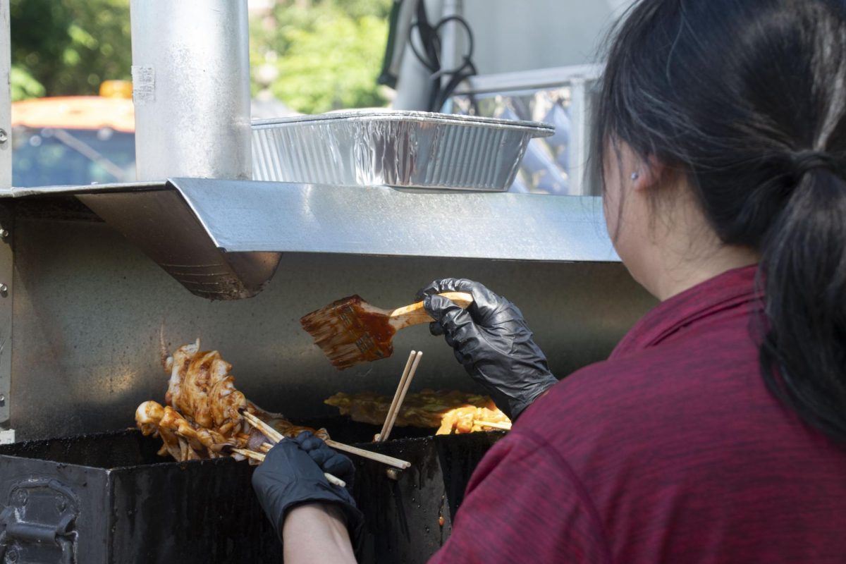 A Rensauce BBQ employee brushes barbecue sauce over chicken skewers. The festival offered a wide array of food and drinks, such as poké, bubble tea and soup dumplings.
