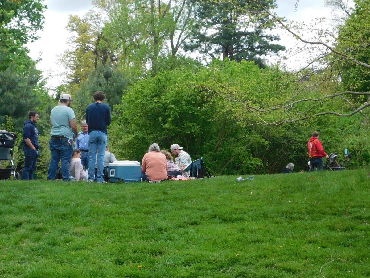 Families picnic near Bussey Hill on Central Street. Many families came to not only see the lilacs bloom but also to eat together and relax in the open atmosphere.