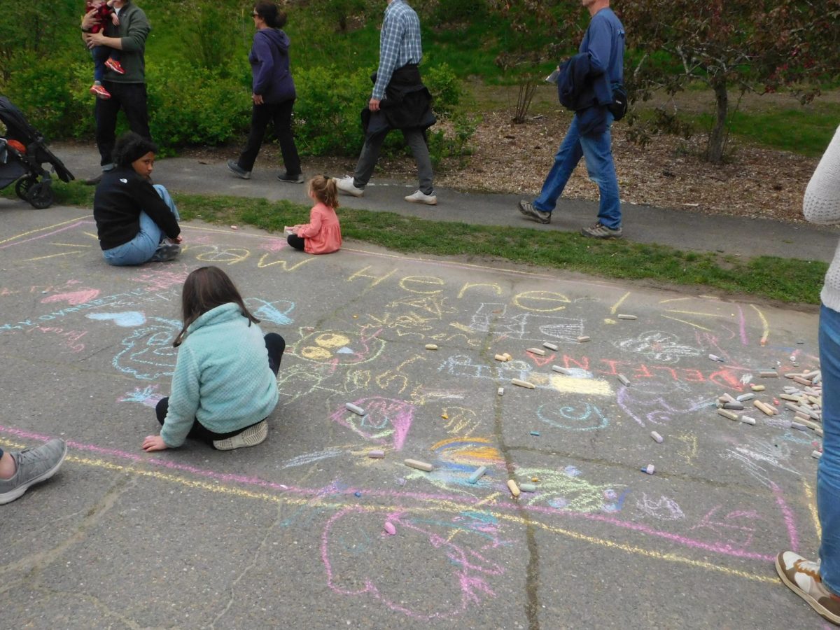 Children draw on the pathway with colored chalk. Professional chalk artists created drawings for Lilac Sunday.