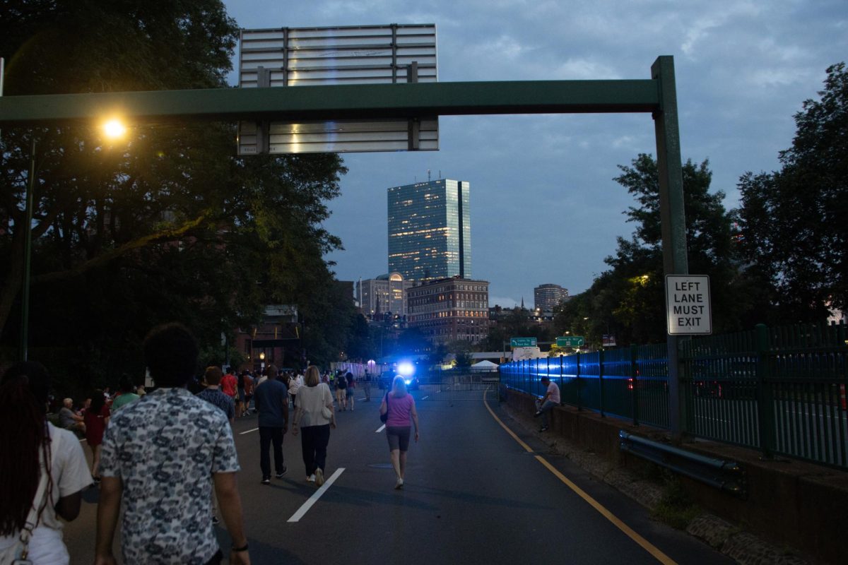 Spectators walk down Storrow Drive as 200 Clarendon St., better known as The Hancock, looms large in the distance. The Boston Police Department shut down streets and bridges along the Charles River to control the flow of pedestrian traffic and patrolled the crowds that gathered with the help of military police.