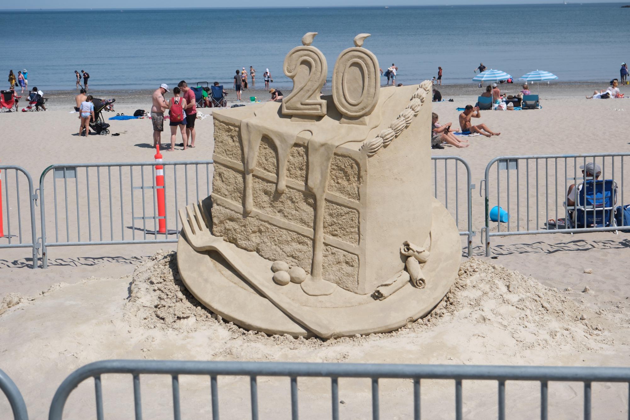 A sand sculpture of a slice of cake signifying the event’s 20th anniversary. Attendees were invited to take pictures with the sculpture to show support for the long-standing tradition.