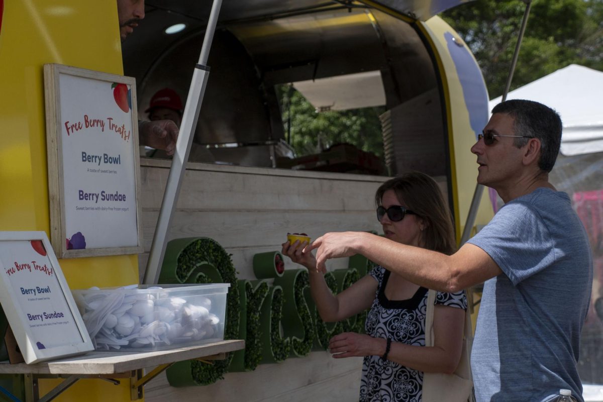 A festivalgoer points to the Driscoll’s truck menu while requesting a free berry treat. Driscoll’s also provided postcards for people to fill out, promising to mail them anywhere in the world for free.