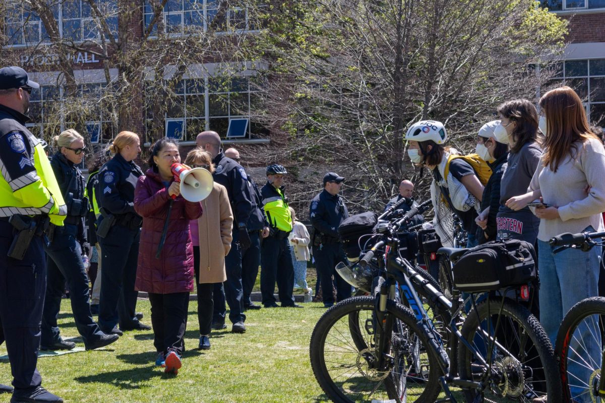 Chong Kim-Wong announces through a megaphone to protesters at the Centennial Common encampment April 25 that they must produce identification proving they are a Northeastern student within 10 minutes or they will be asked to leave campus. Some administrators, including Kim-Wong, were accused of verbally intimidating protesters during the encampment in the complaint against Northeastern.