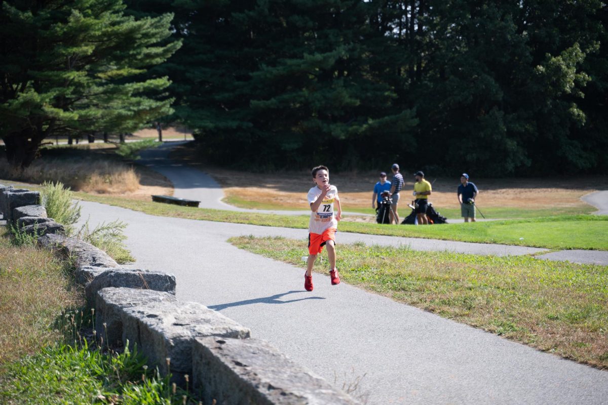 A child participant runs along the race path.