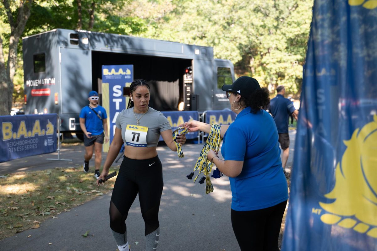 A runner accepts a medal at the finish line.