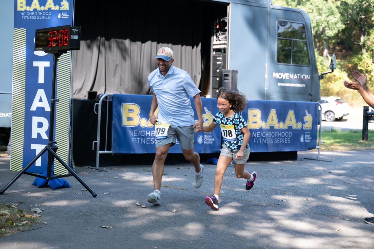 A parent and child run together to the finish line. The race series was started in fall 2022 and was sponsored by Boston Children's Hospital.