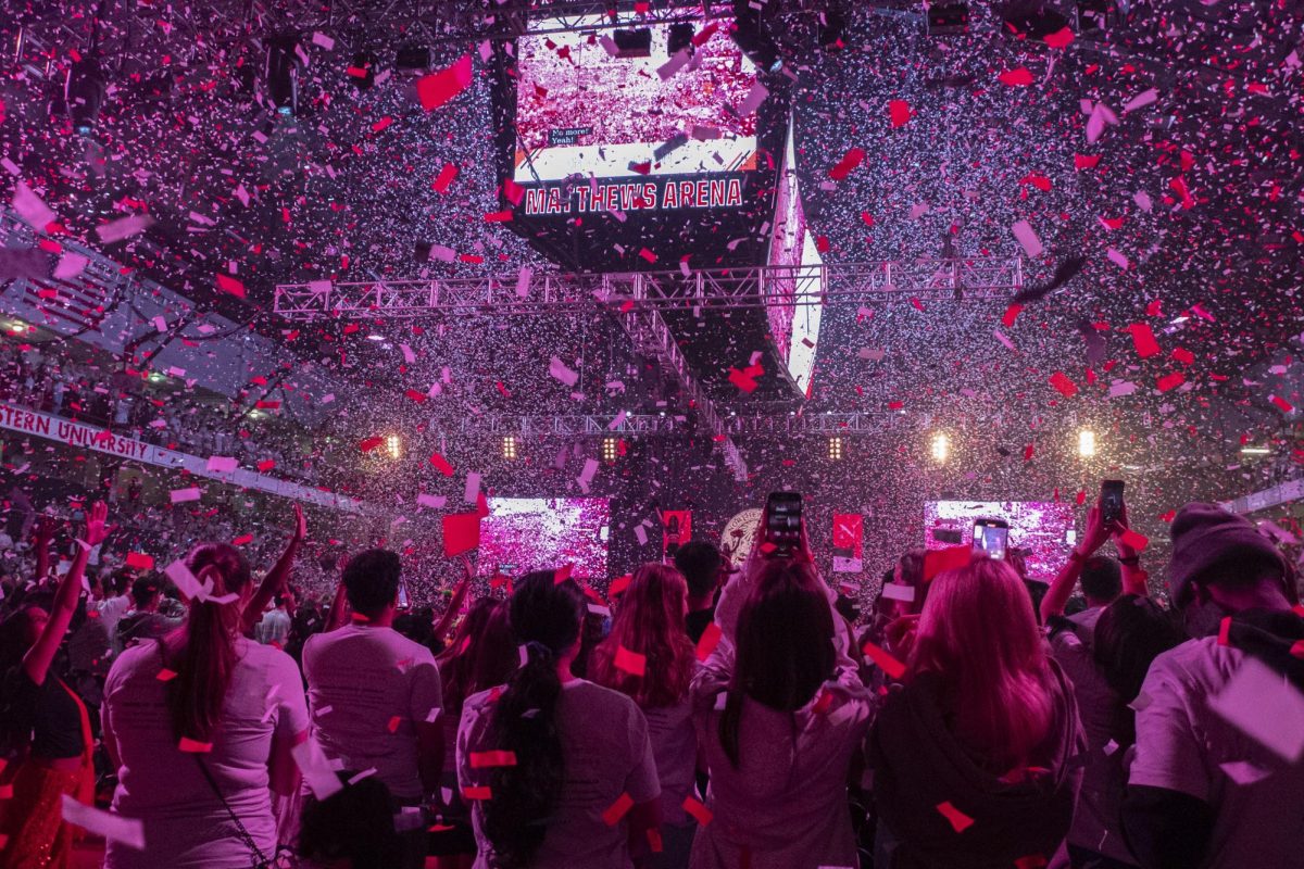 Members of the class of 2028 stand up at the end of convocation as confetti falls in Matthews Arena. Nearly 5,000 students attended the celebration in Boston.