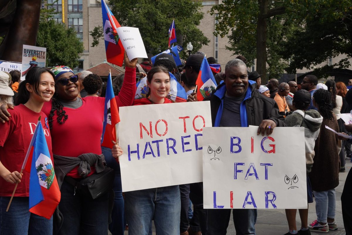 Rally participants hold up flags and posters. The rally aimed to support Haitian immigrants in Springfield, Ohio who have recently faced a flood of hate and threats.