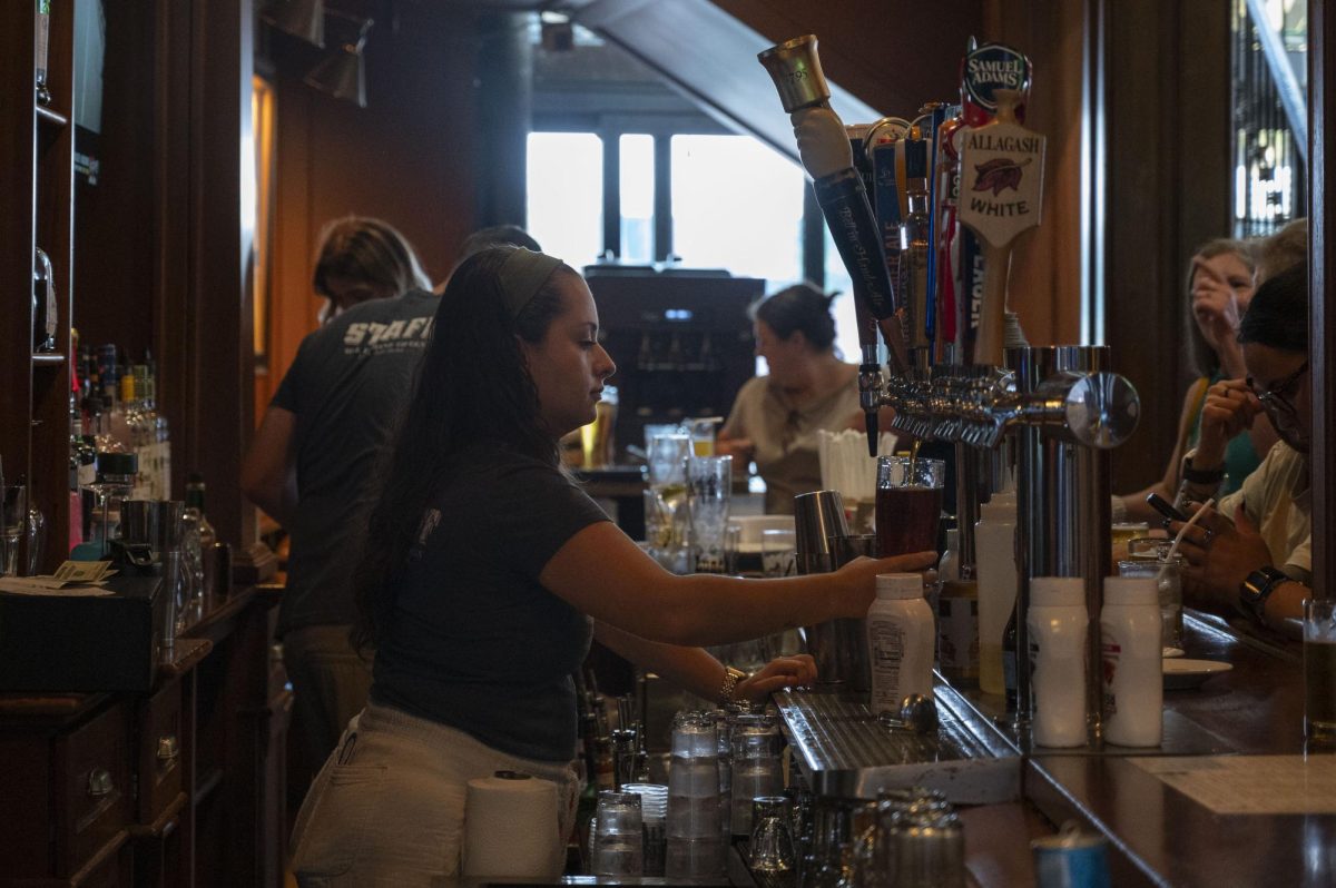 A bartender prepares a glass of beer at Bell in Hand. An amendment that would remove the state's happy hour ban was approved in July by the Massachusetts Senate.