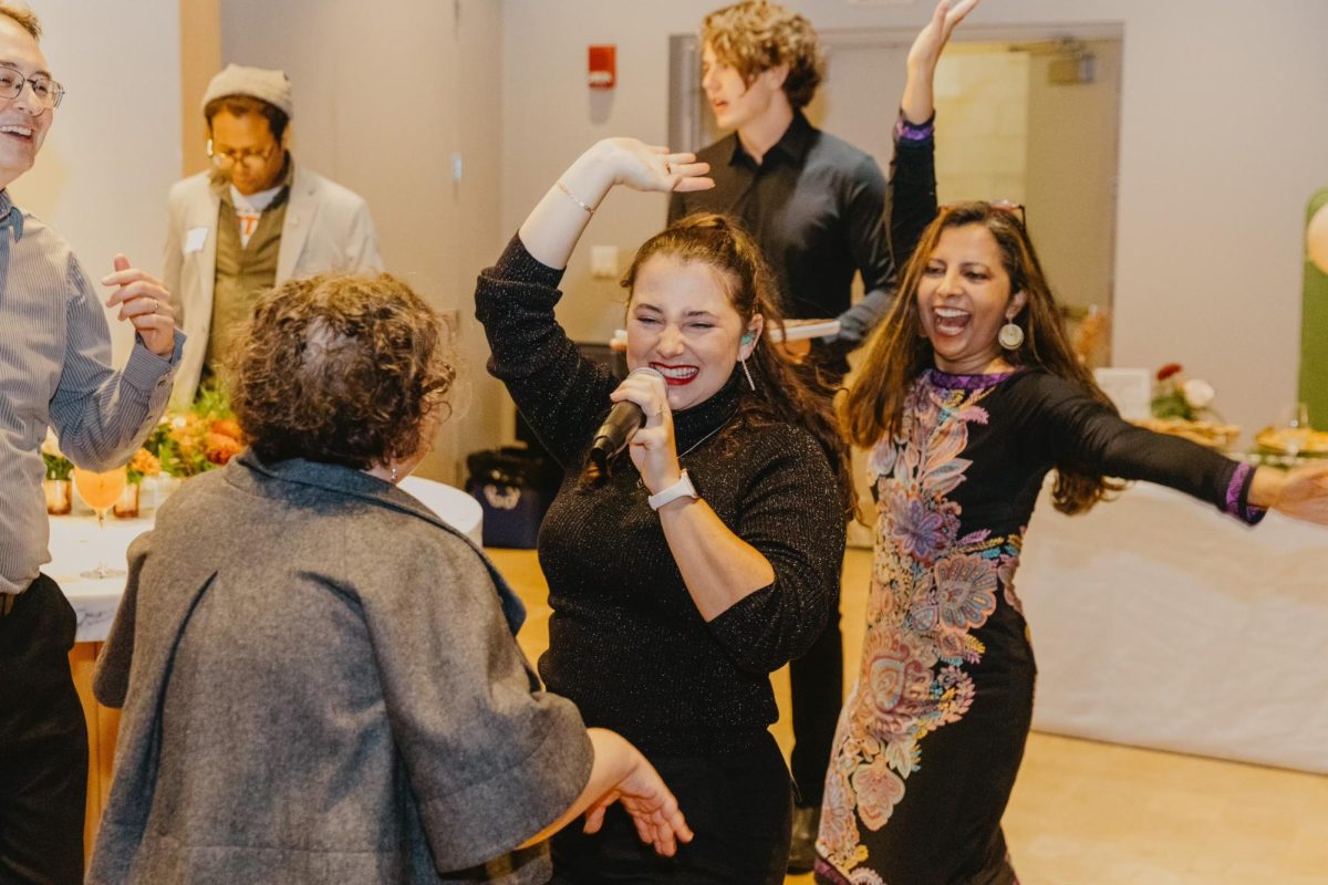 People dance around a woman with a microphone. The FCC started in 2016 and was a part of Fenway Cares, established in 2020. Photo courtesy Fenway Community Center.