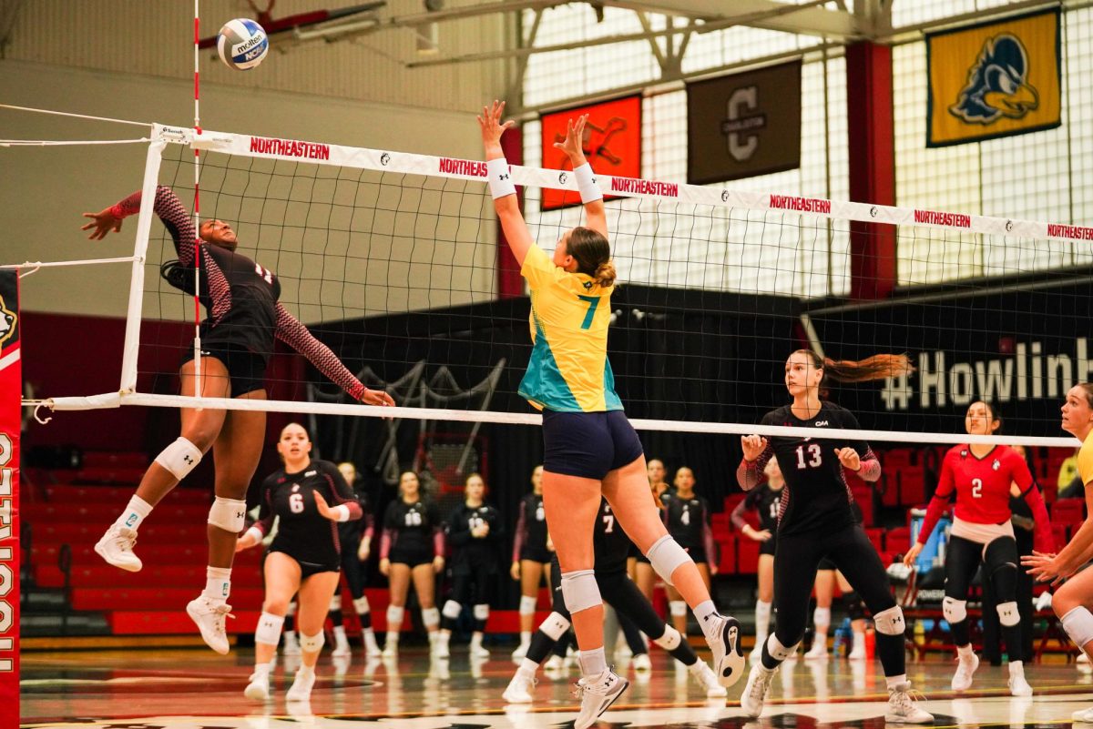 Kaylin Daniels jumps for the hit against UNCW Sept. 22. The Husky was the game leader in blocks, tallying nine.