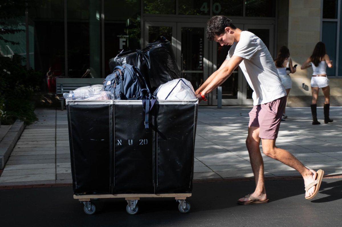 A student pushes a cart while moving into an on-campus residence hall Sept. 2.