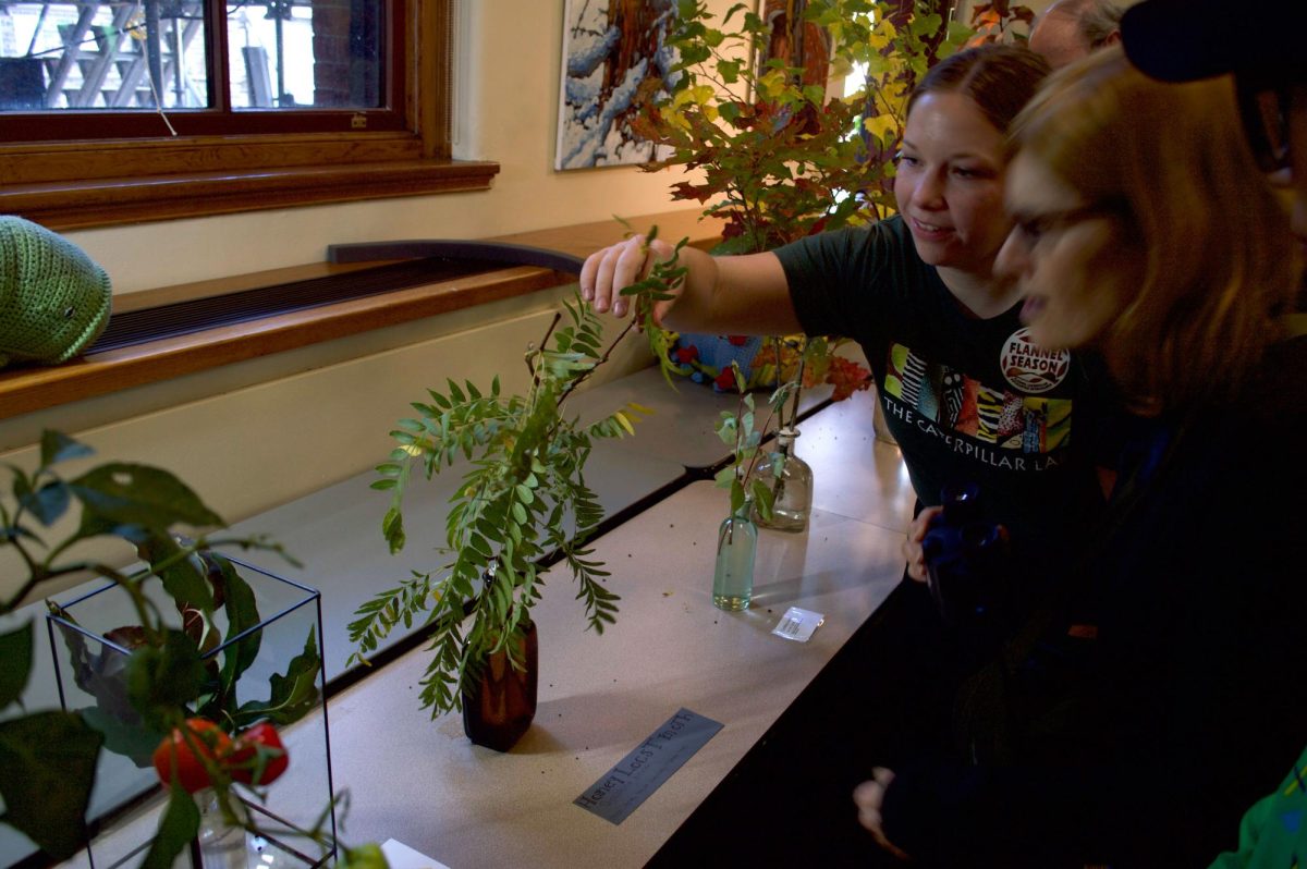 Burns points out a camouflaged caterpillar to an attendee. There were multiple Caterpillar Lab employees educating and answering questions at the event.